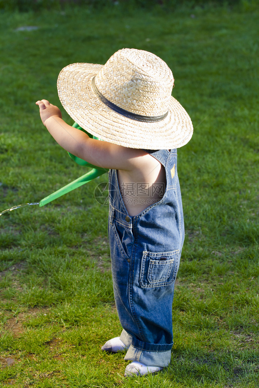 一个戴着草帽的男孩 一个年轻的园丁 享受春天花园婴儿幸福快乐植物童年女孩乐趣公园孩子图片