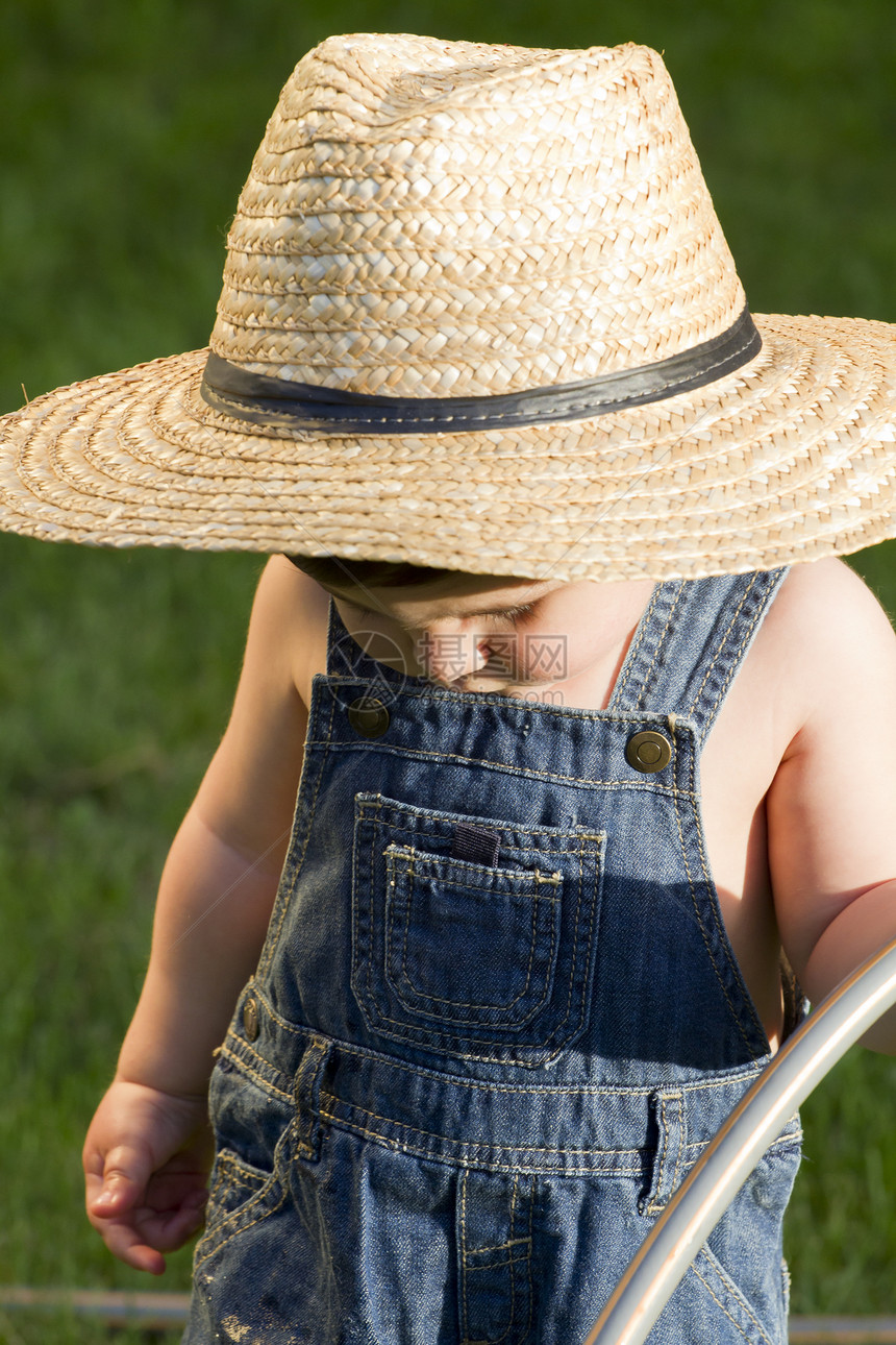 一个戴着草帽的男孩 一个年轻的园丁 享受春天快乐乐趣幸福男生花园喜悦植物孩子女孩园艺图片