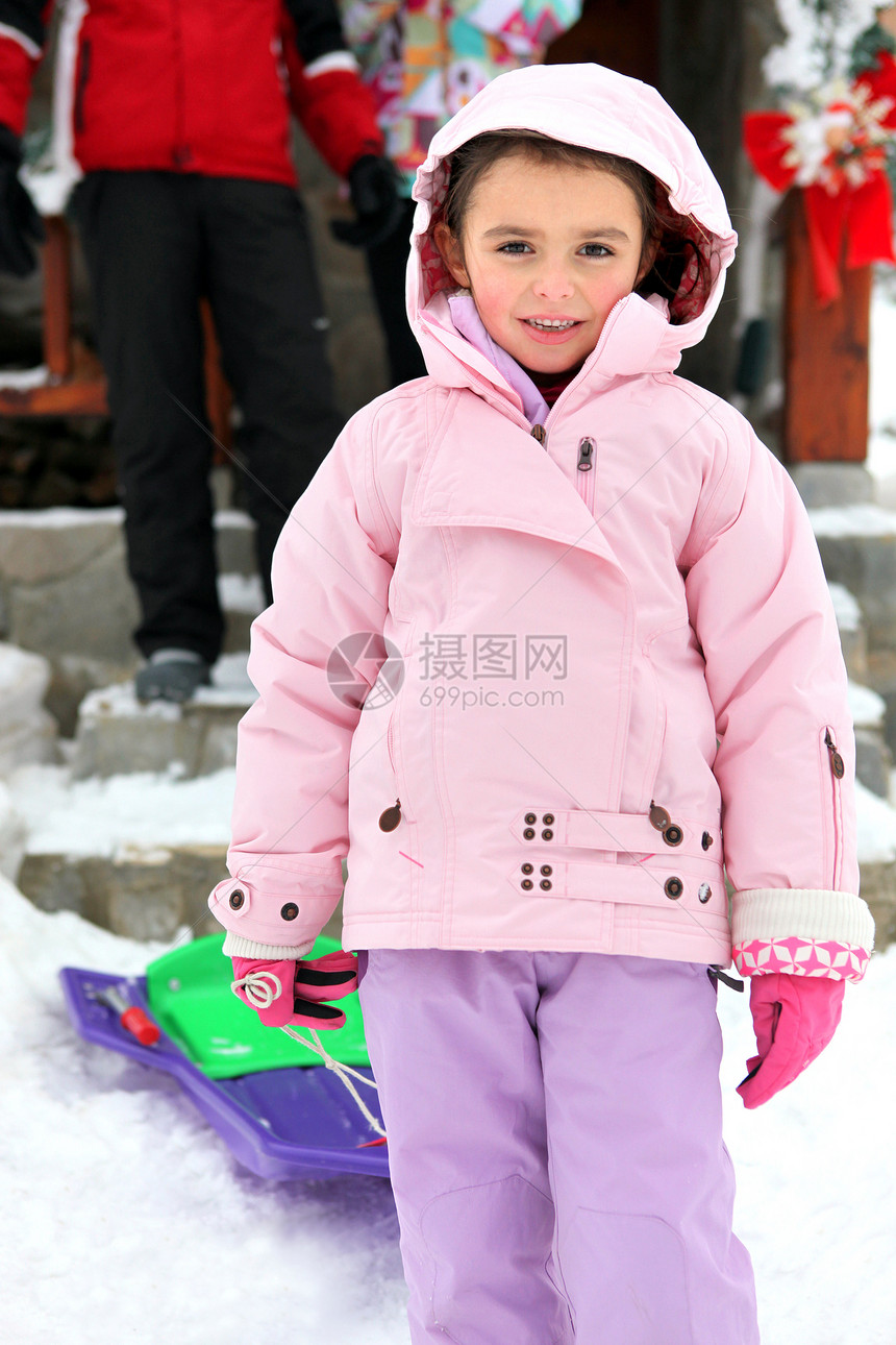 穿雪衣的小女孩拿着雪橇图片