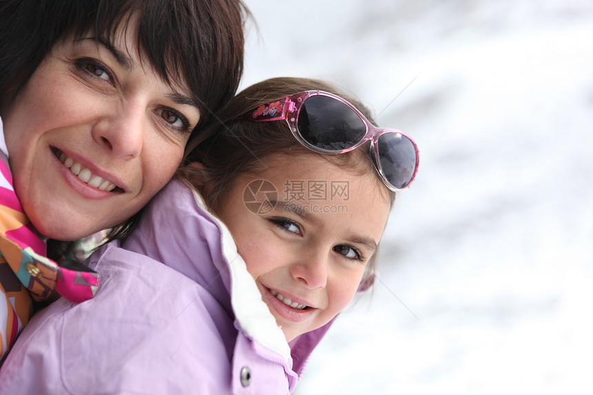 母亲和女儿在雪中玩耍感情夫妻女性滑雪闲暇青年快乐娱乐童年假期图片