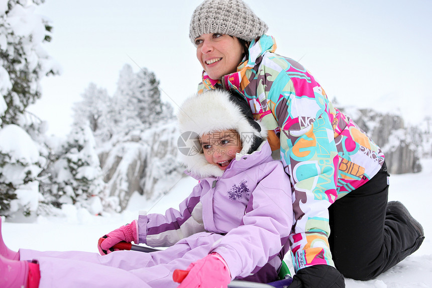 母亲和女儿一起在雪中玩耍毛皮仙境孩子温度树木母性寒冷乐趣帽子妈妈图片