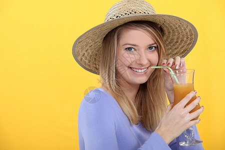 女人喝鸡尾酒饮食金发果汁果味稻草女士女孩水果玻璃淬火快乐的高清图片素材