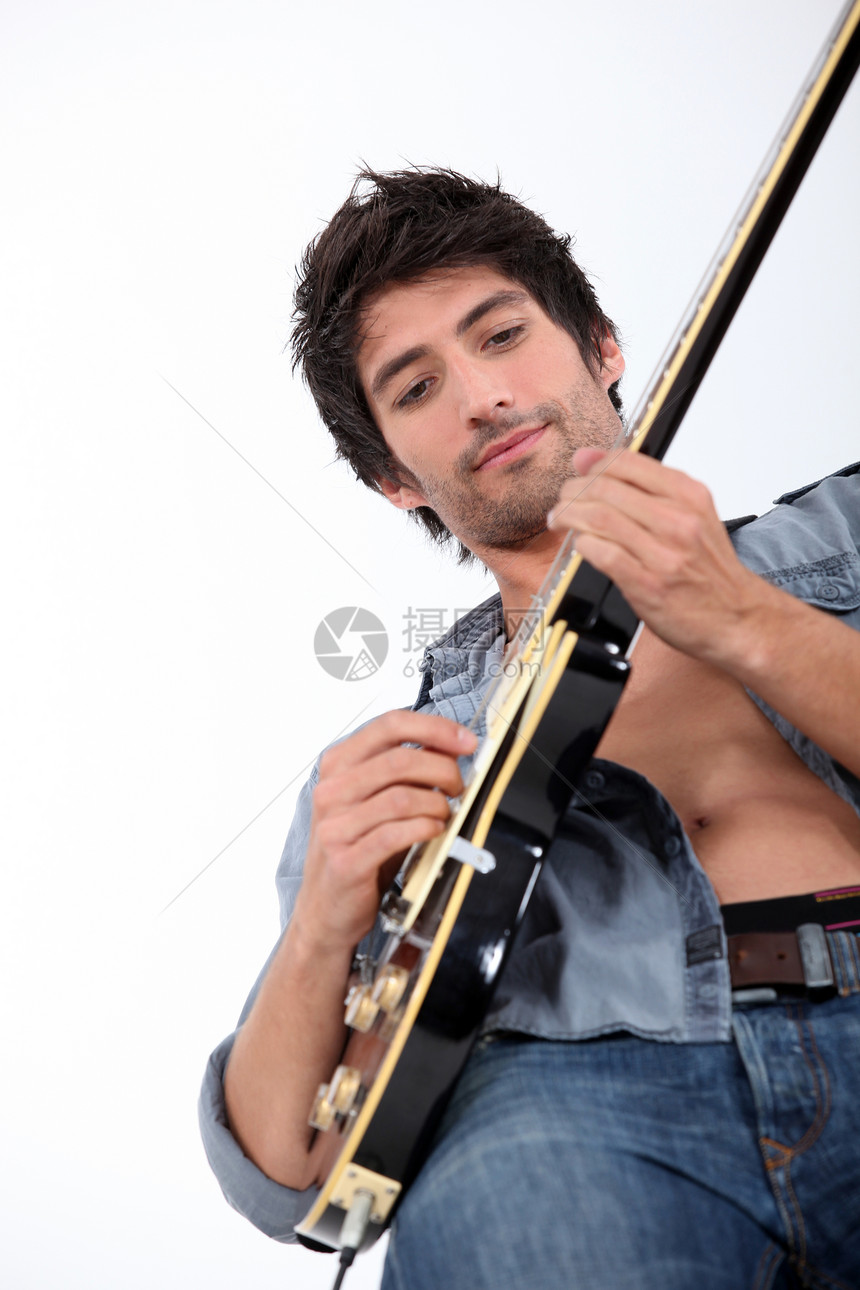 年轻人弹吉他时的景象图片