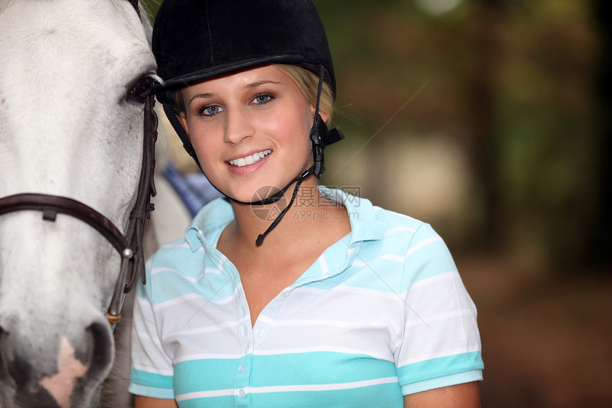 年轻女人和她的马匹骑马骇客骑术皮革国家头盔牧场游客动物帽子图片