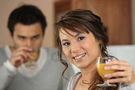 一对夫妇喝橙汁长发娱乐好女孩生活头发水合物杯子早饭营养黑发维生素高清图片素材