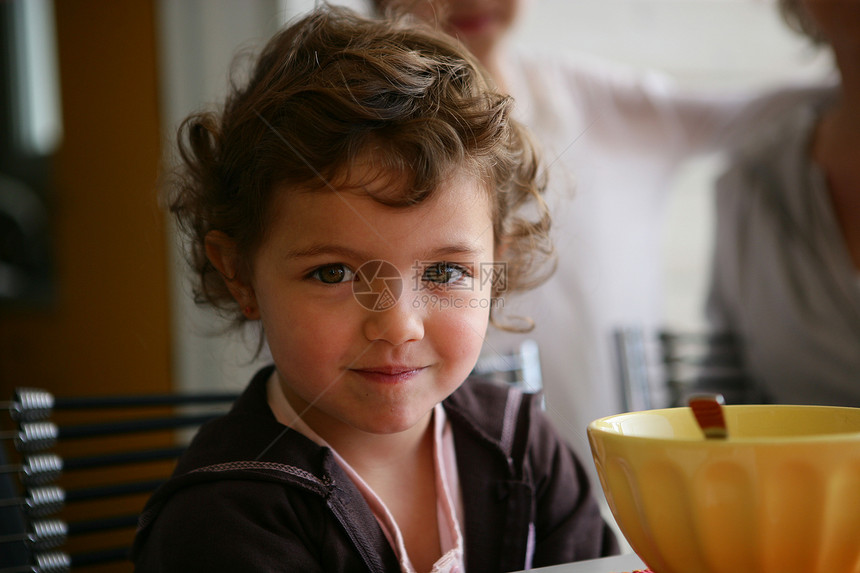 小女孩坐在早饭桌前图片