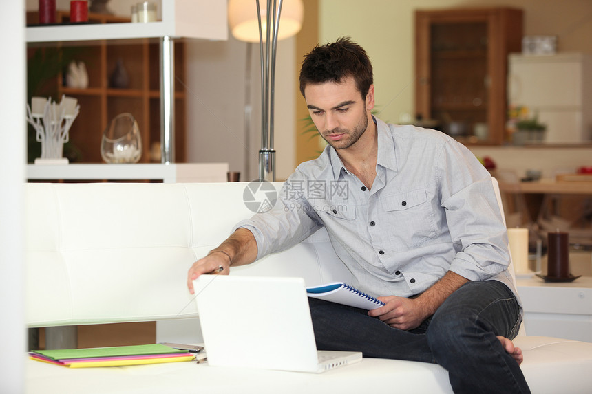 男人用电脑坐在沙发上图片