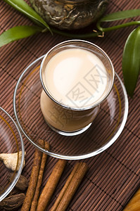 马萨拉沙伊牛奶树叶泡茶小豆蔻叶子玻璃杯香料香菜肉桂时间背景图片