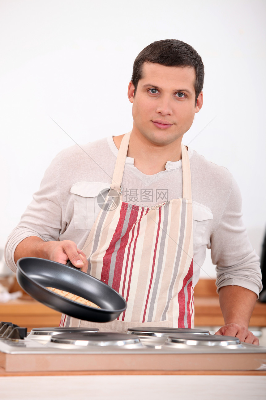 男人烹饪条纹平底锅电烤箱工作男性厨房油炸食物力量红色图片