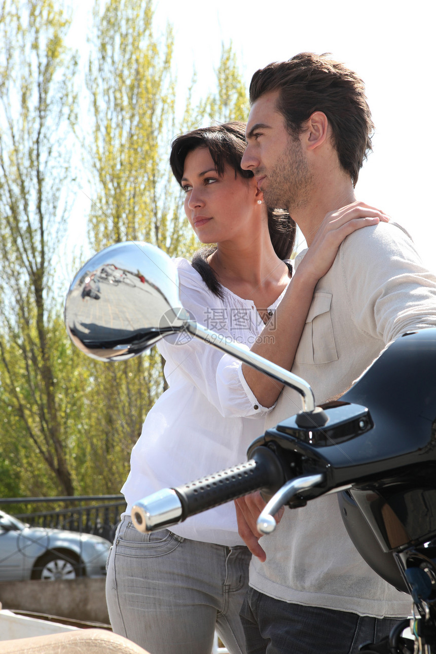 情侣站在他们的摩托车旁图片