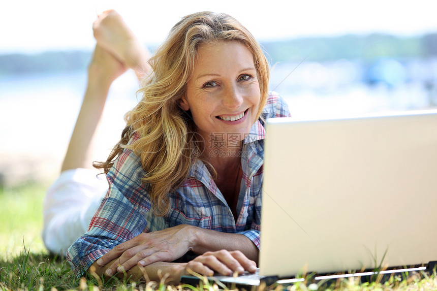 妇女在外面的笔记本电脑上白色金发成年人女性女士公园草地头发微笑图片