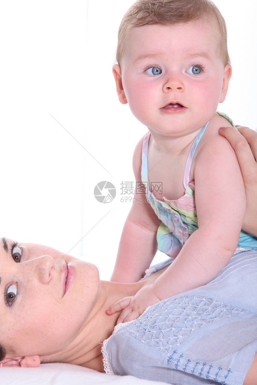 母亲与她的女婴在胸前玩耍图片