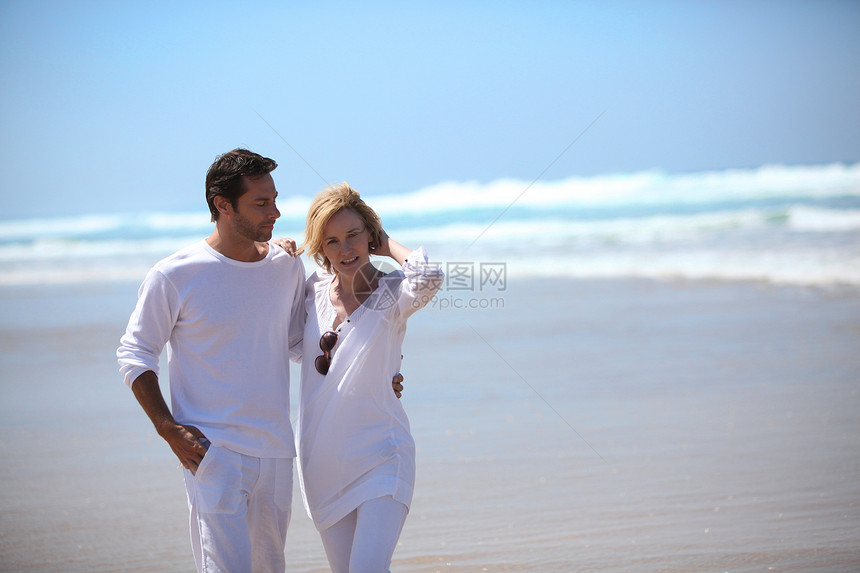 一对夫妇在海滩上散步夫妻天空微笑女士眼镜妻子海滩太阳丈夫男人图片