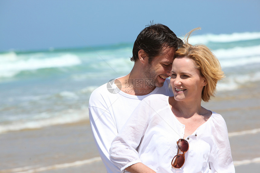 情侣在海滩上拥抱月亮支撑蜂蜜太阳旅行女士夫妻假期享受波浪图片