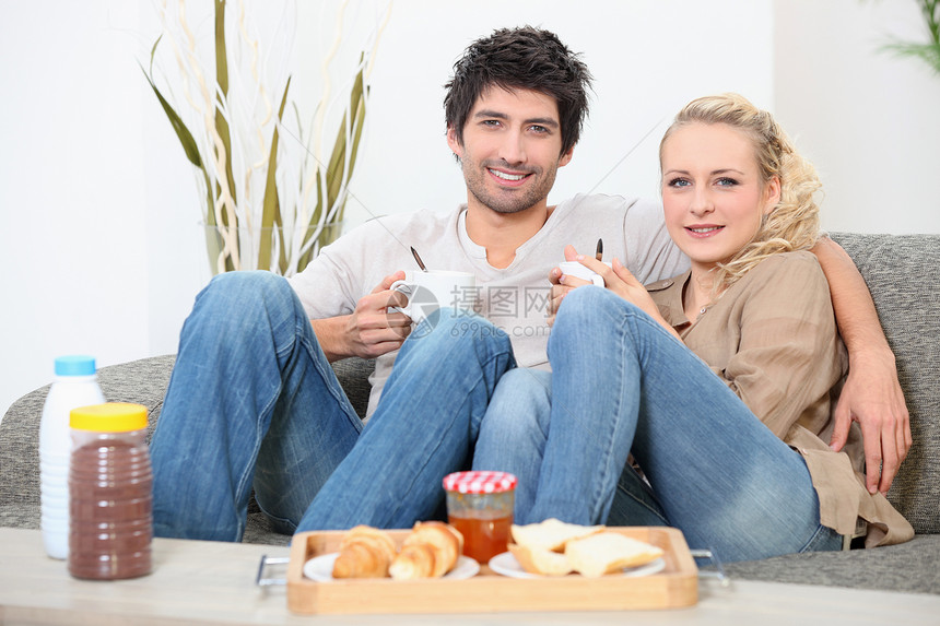 夫妇吃早餐肩膀杯子丈夫夫妻沙发微笑面包长椅金发咖啡图片