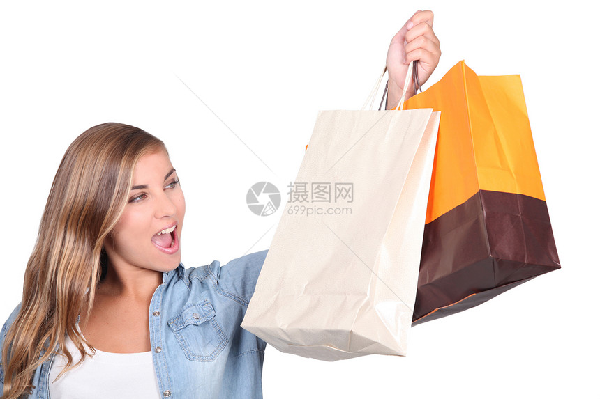 金发女人站着拿着购物袋图片