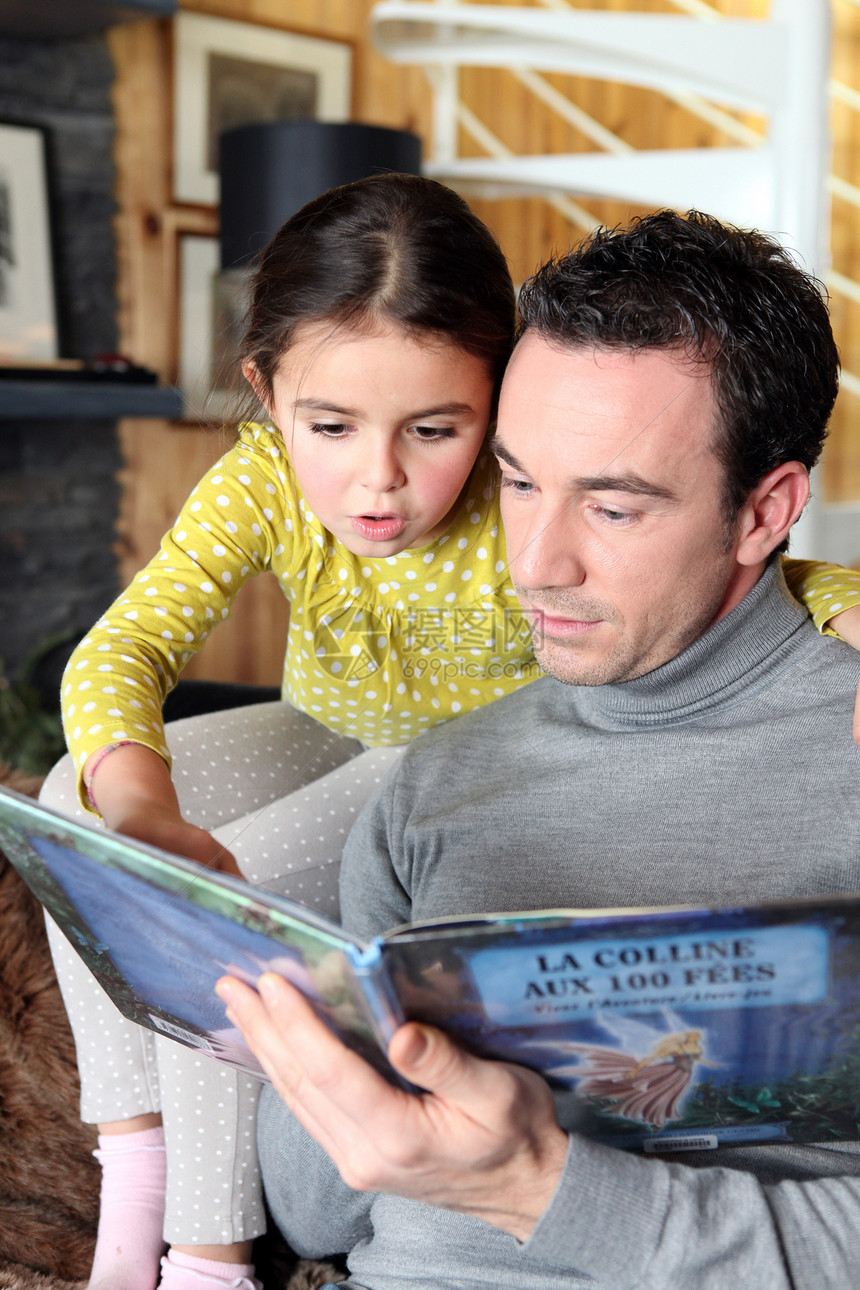父亲和女儿在读一本书幸福女孩闲暇男人团体男性孩子时间家庭微笑图片