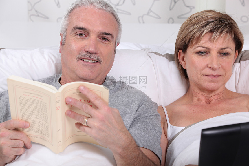 在床上看书的情侣枕头爱好异性闲暇电脑男人卧室技术丈夫女性图片