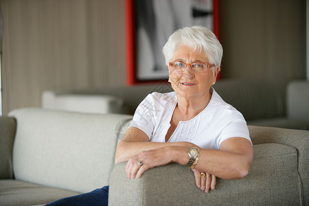老年妇女在沙发上放松音乐幸福眼镜家庭风化灰色眼睛女士祖父母压痛背景图片