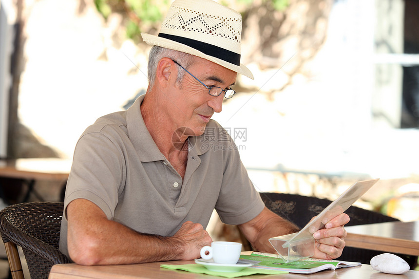 老年男子饮喝咖啡杂志好天气小时帽子桌子咖啡时间小册子杯子男人图片