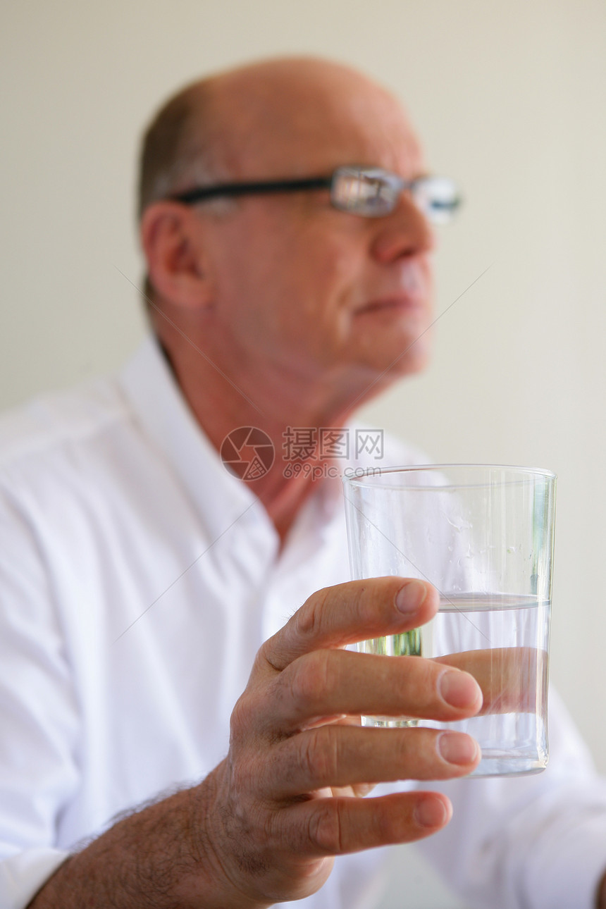 老年男子用水杯服药的年长男子图片