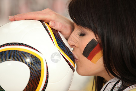 年轻德国黑发小子亲吻足球球背景图片