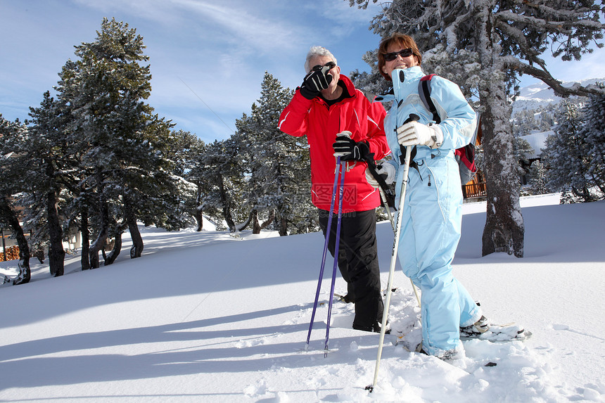 成人滑雪夫妇娱乐男人太阳齿轮退休乐趣树木帽子男性旅行图片