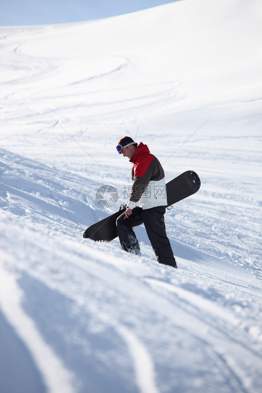 滑雪运动员爬上山边图片