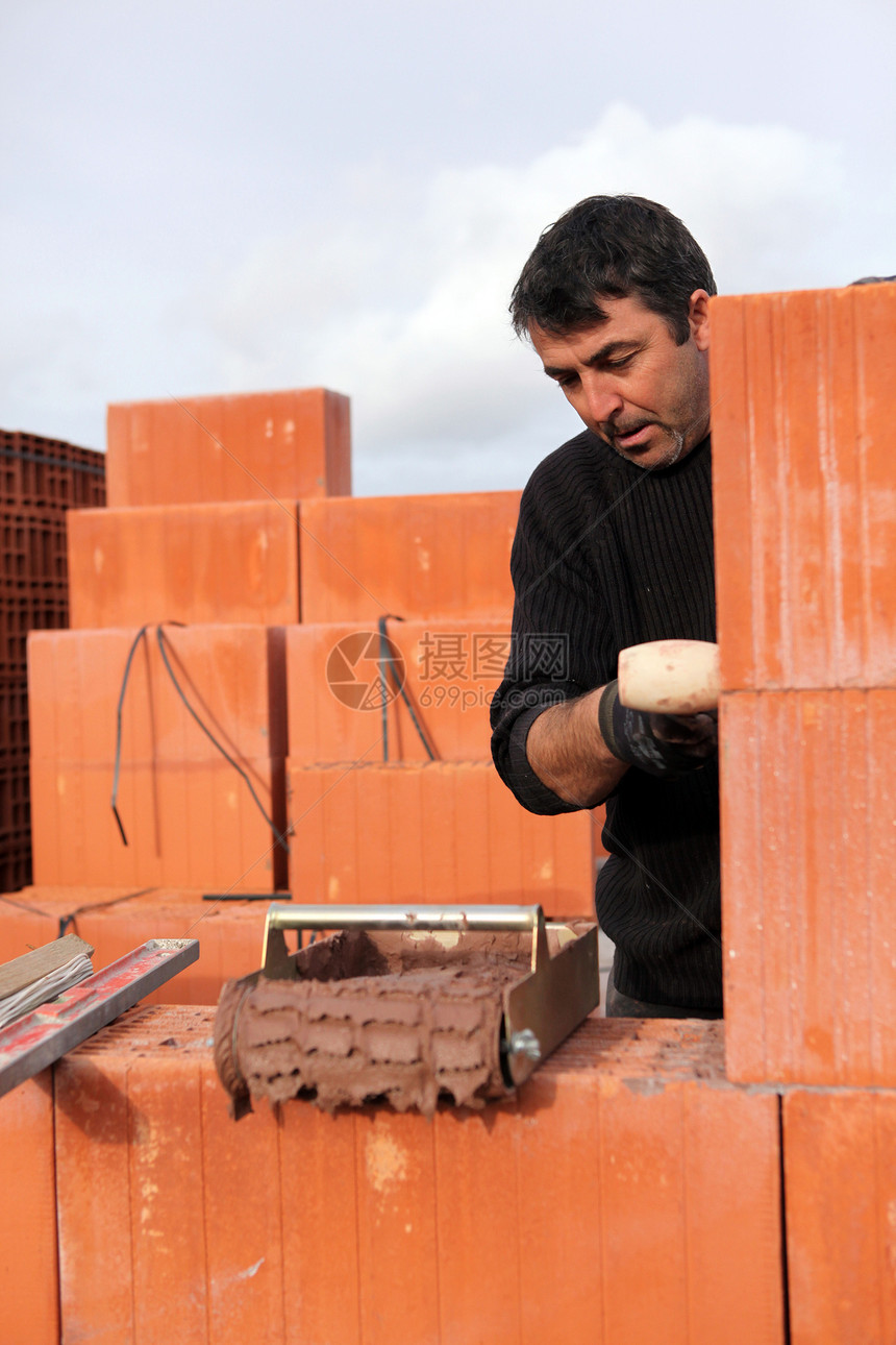 一个忙着工作的砖匠活动修理陶瓷托盘瓦工石工建造男人测量石匠图片