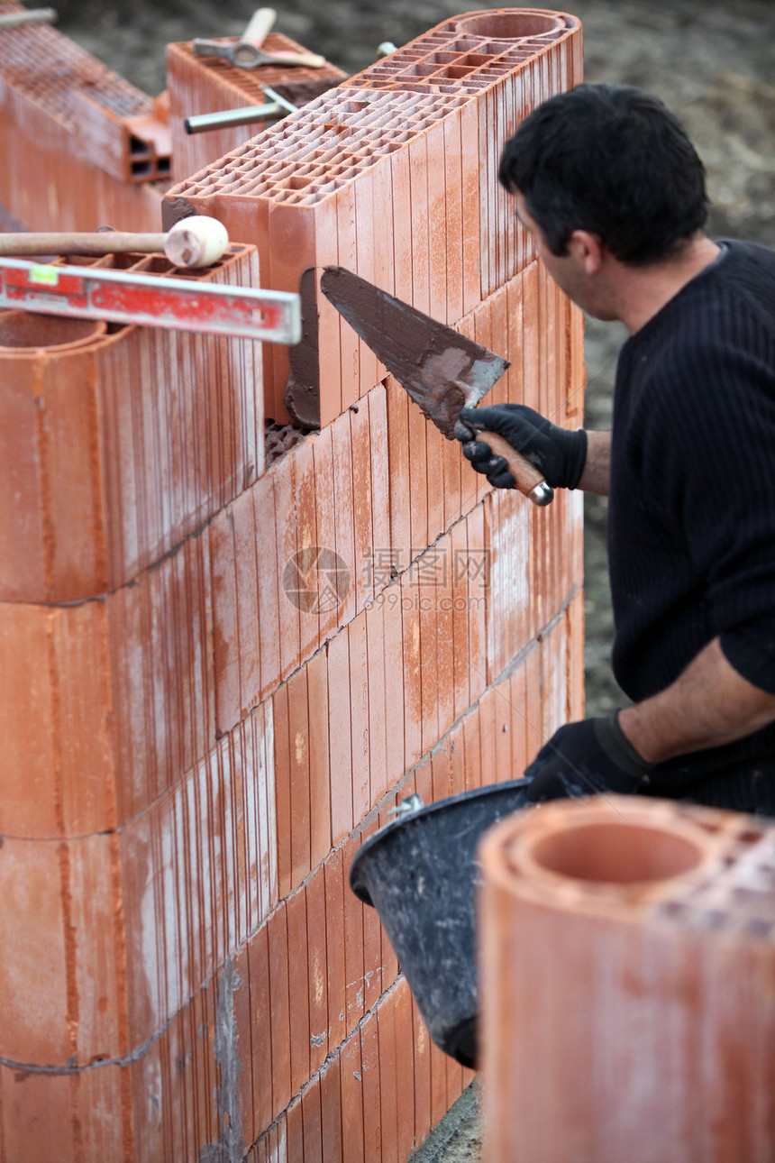 带块墙的建设器石匠工作建造瓦工工作服石头房子职业石工工人图片