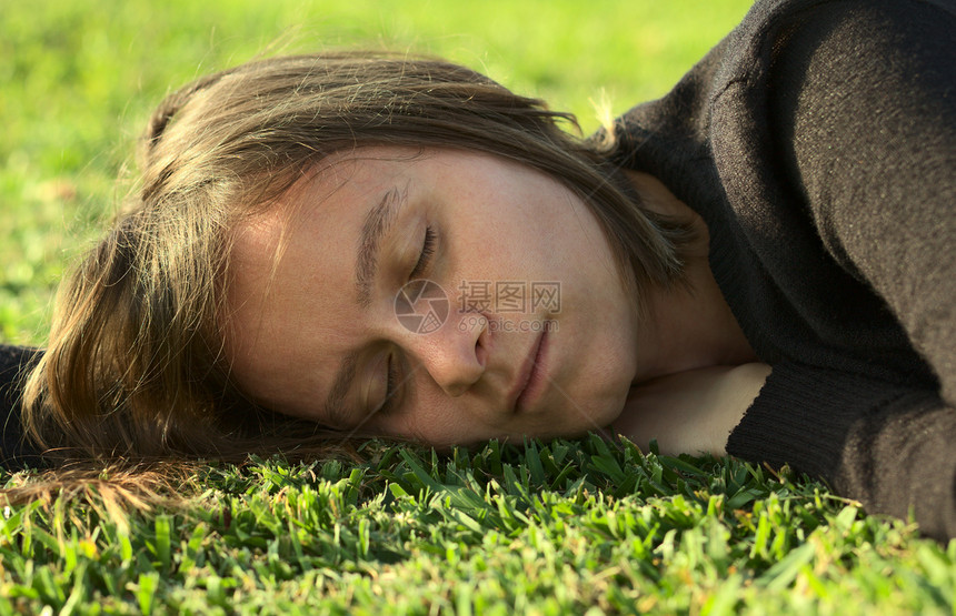 睡在草地上的青年妇女说谎绿色白色水平照片休息公园女性睡眠图片