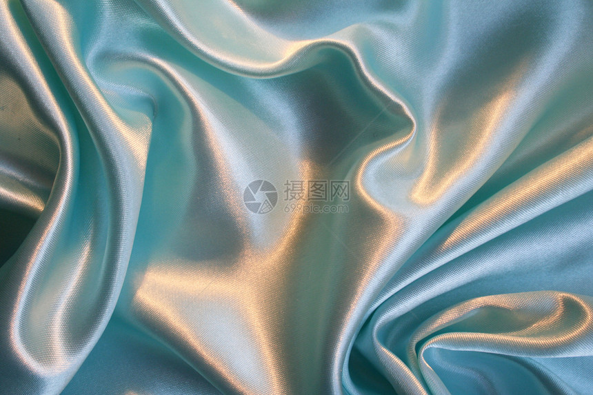 平滑优雅的蓝色丝绸作为背景织物礼物折痕曲线感性材料版税投标纺织品布料图片
