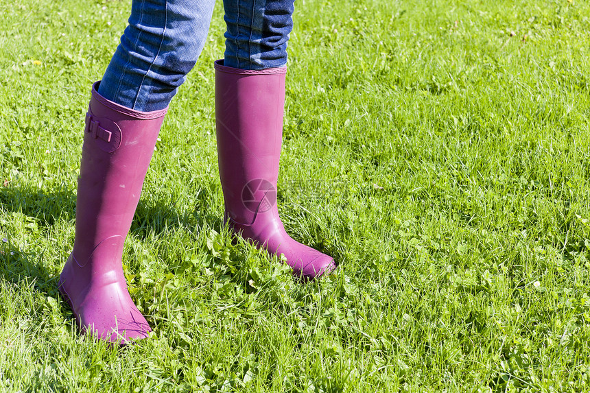女性在草坪上穿着橡胶靴子的详情外观裤子牛仔裤鞋类成人牛仔布紫色草地女士图片