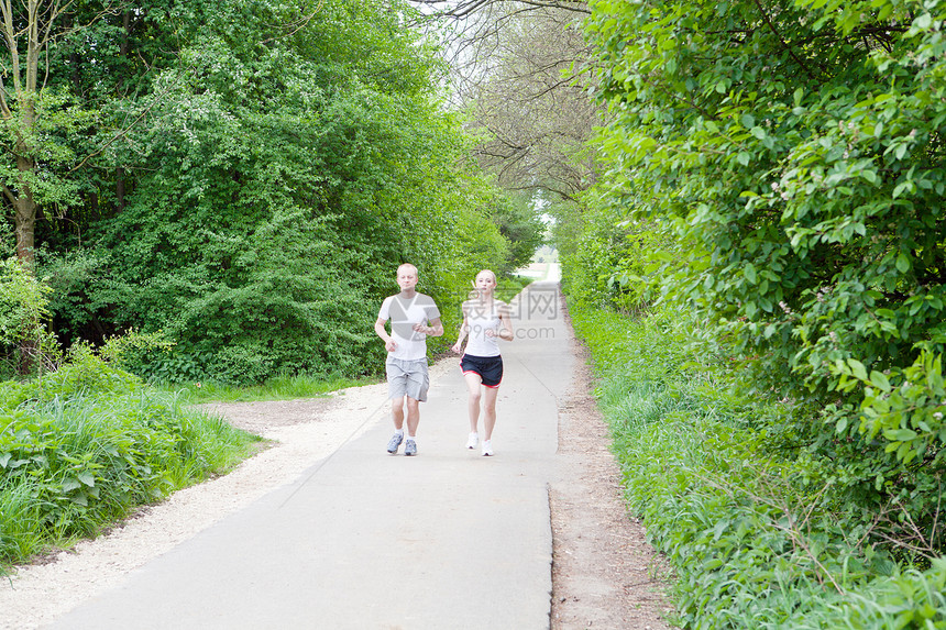 年轻夫妇在森林里慢跑公园夫妻成人运动训练活动运动员健康活力慢跑者图片