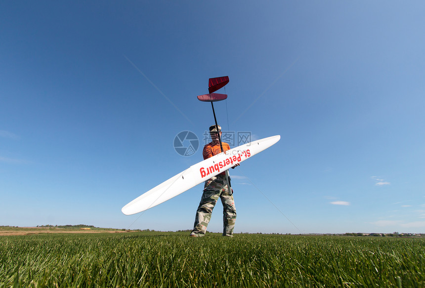 男人拥有RC滑翔机收音机闲暇速度飞行员发射螺旋桨场地空气控制蓝色图片