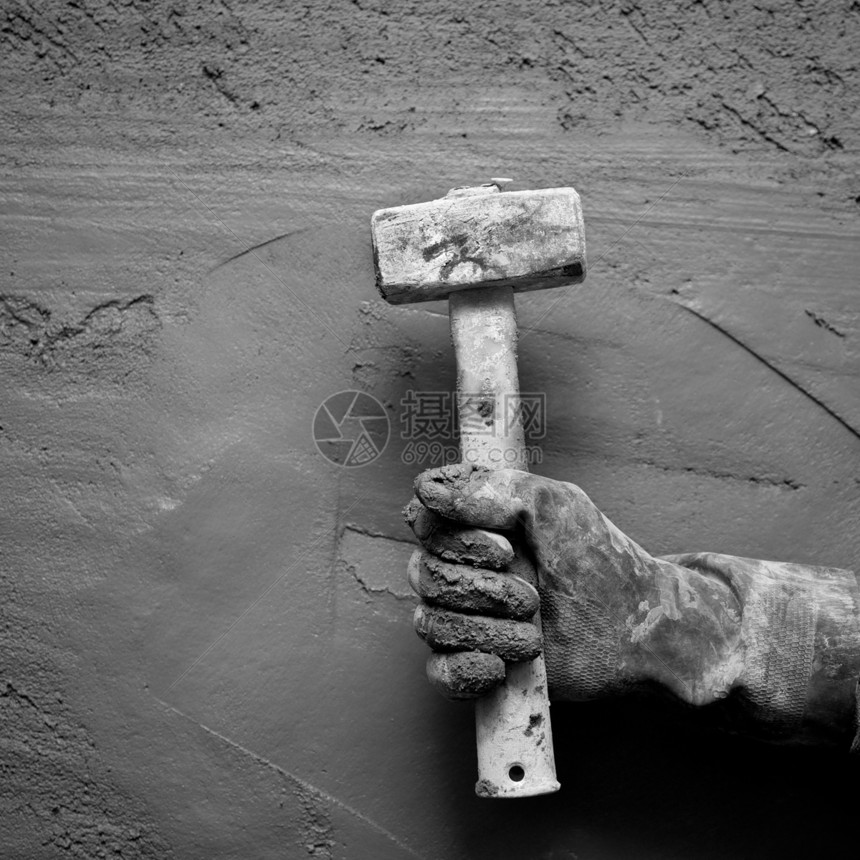 带手套的铁锤人 在石水泥背景下石头衰变拼装乡村维修建筑学工作石匠石工石膏图片