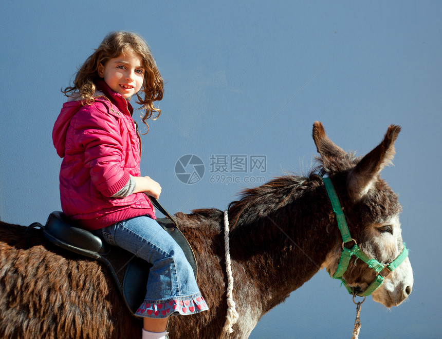 驴子和小小女孩一起快乐地骑马图片