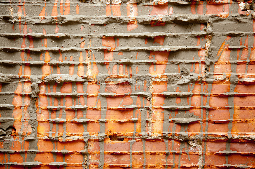 修复墙壁的砖墙中的破碎砖砖风化石膏衰变橙子乡村砂浆手工维修房子水泥图片