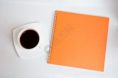 黑咖啡和橙色笔记本水平咖啡杯子摄影空白背景图片