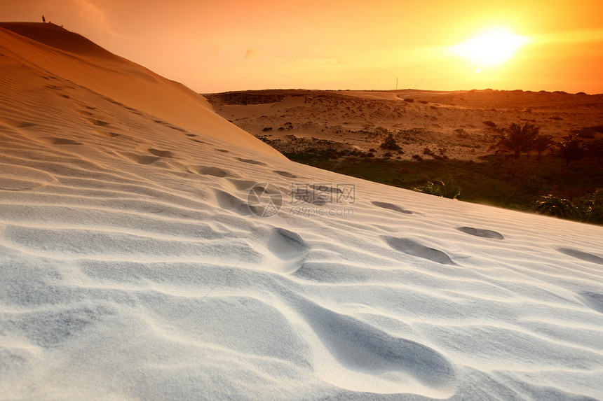 沙漠地区新月形干旱寂寞旅游爬坡波纹勘探孤独游客日落图片