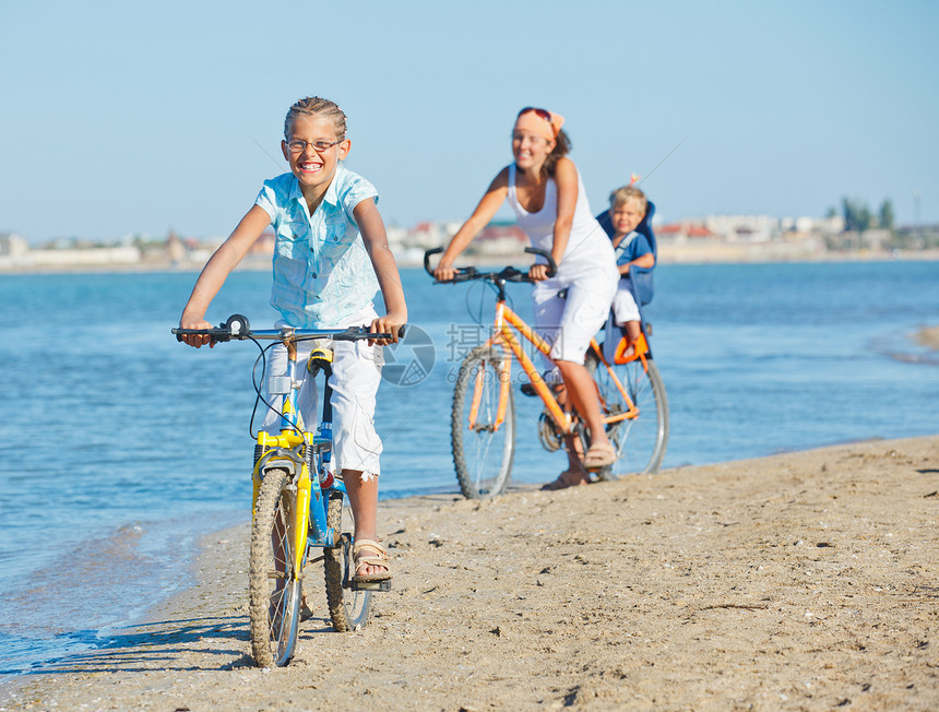 可爱的女孩和她的母亲和兄弟一起骑自行车微笑儿子海滩男生女士女性海洋喜悦运动幸福图片