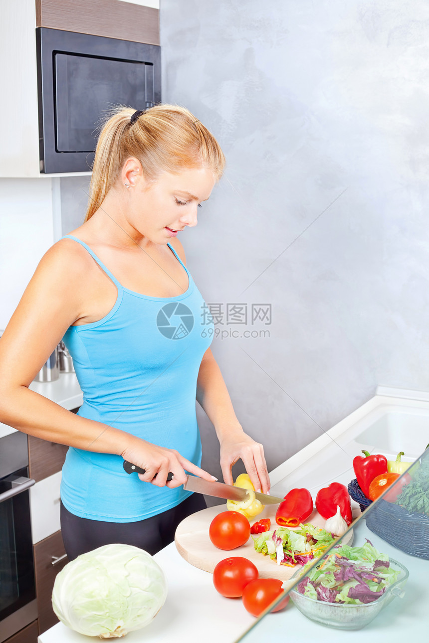 厨房切菜蔬菜中的年轻女性图片