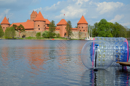 水上充气城堡在特拉凯城堡加尔维湖附近的水上进行搜捕背景