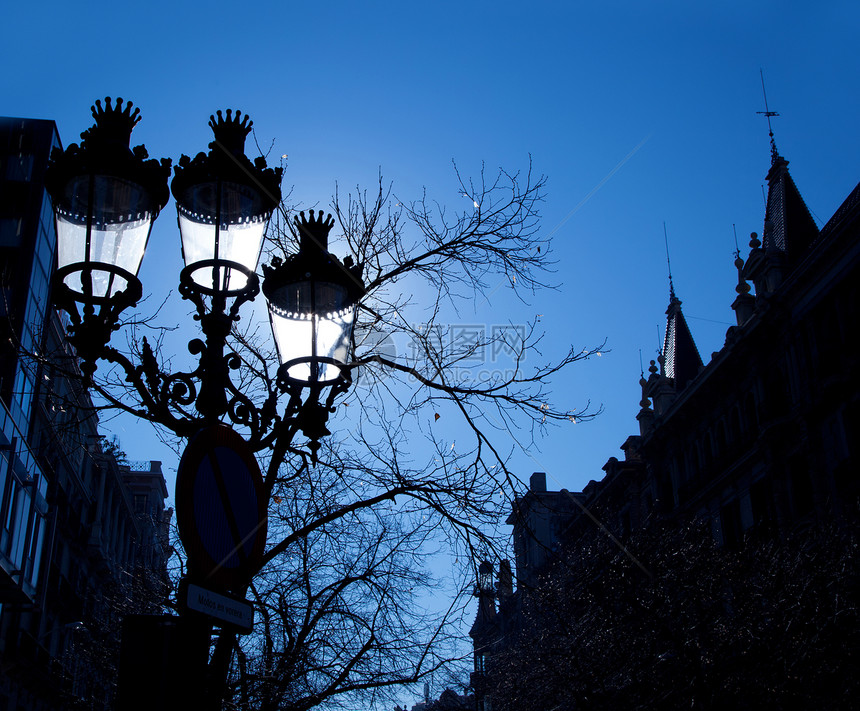 巴塞罗那街灯的背面戏剧性光灯辉光微光天空大道照明历史灯笼火焰图片