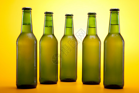 黄色背景的冷冻啤酒酒吧饮料棕色液体玻璃金子茶点琥珀色瓶子气泡背景图片