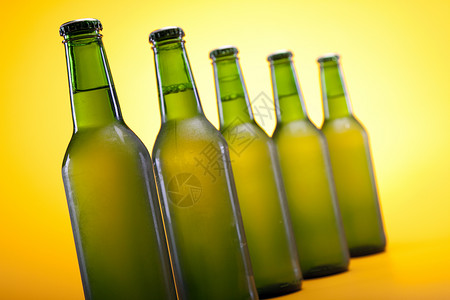 黄色背景的冷冻啤酒酒吧冷藏液体气泡琥珀色饮料玻璃瓶子棕色茶点背景图片