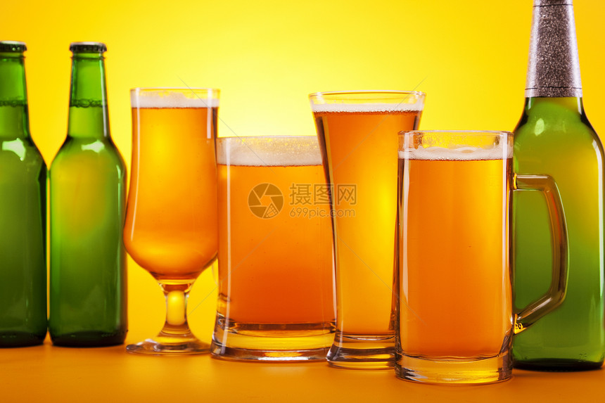 黄色背景的冷冻啤酒茶点琥珀色气泡瓶子饮料冷藏派对液体金子棕色图片