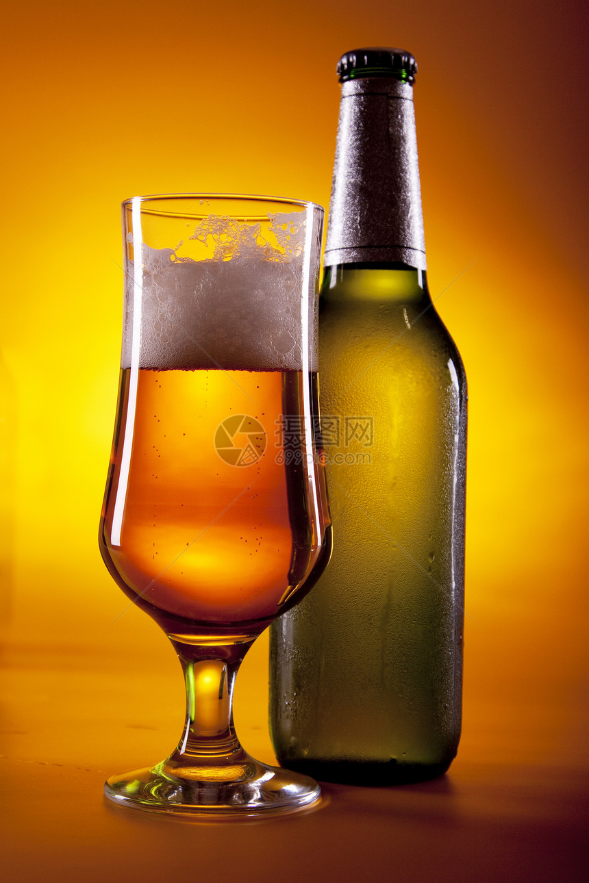 黄色背景的冷冻啤酒琥珀色气泡金子玻璃瓶子茶点冷藏棕色派对液体图片