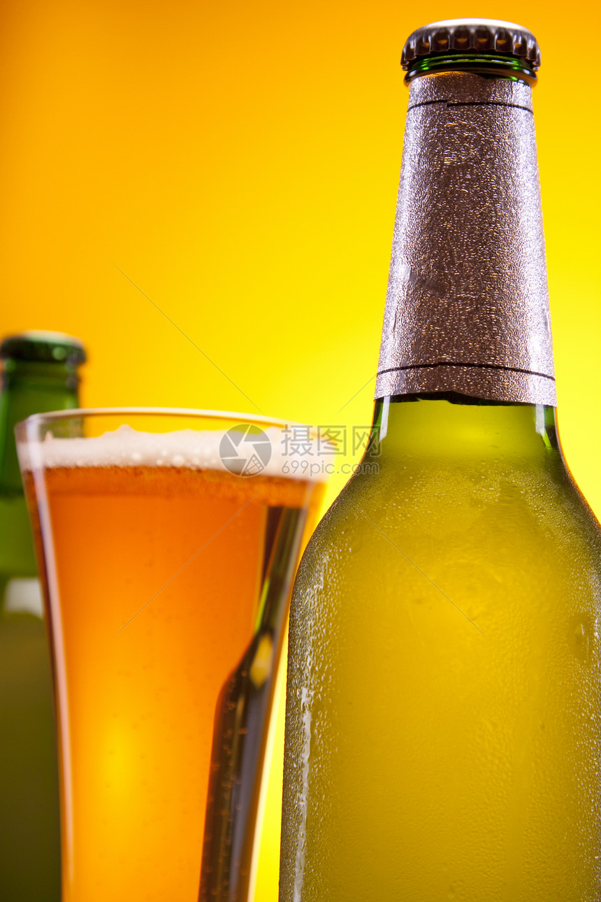 黄色背景的冷冻啤酒冷藏玻璃液体琥珀色饮料金子气泡瓶子棕色酒吧图片