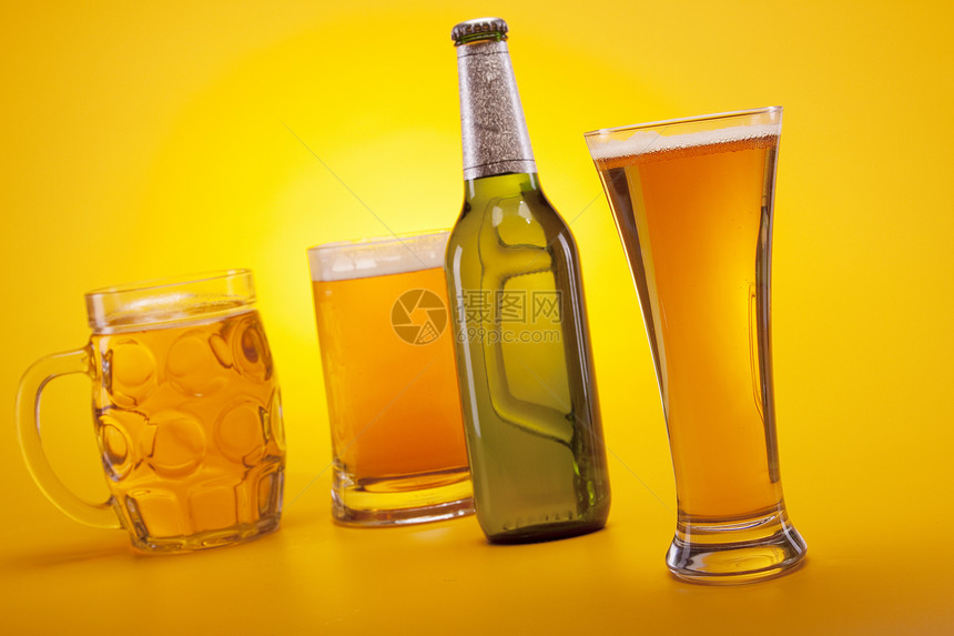 黄色背景的冷冻啤酒金子派对液体琥珀色酒吧玻璃瓶子气泡饮料茶点图片